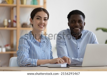 Happy diverse company mentor and African intern at office training center workplace, looking at camera, smiling. Business team coworkers, two employees, student and teacher head shot portrait