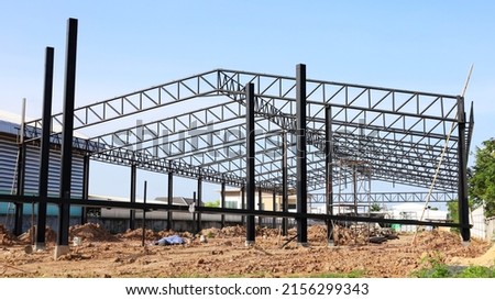 Warehouse metal structure. Detail of industrial warehouse construction with steel structure under construction on clear sky background. Selective focus Royalty-Free Stock Photo #2156299343