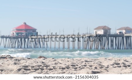 Retro huntington pier, surfing in ocean waves and sandy beach, California coast near Los Angeles, USA. American diner, sea water, beachfront boardwalk, summer vacations. Seamless looped cinemagraph. Royalty-Free Stock Photo #2156304035