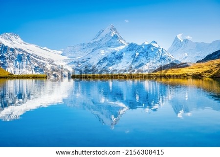 High mountains and reflection on the surface of the lake. Mountain valley with lake. Landscape in the highlands in the summertime. Photo in high resolution.
