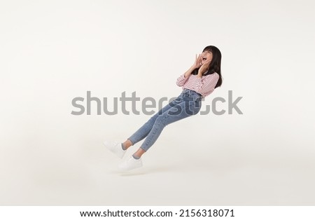 Young beautiful smiling asian girl floating in mid-air shout story and announcement something isolated on white background. Royalty-Free Stock Photo #2156318071
