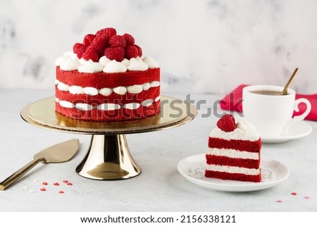Red velvet cake decorated with raspberries  on a golden stand. Selective focus Royalty-Free Stock Photo #2156338121