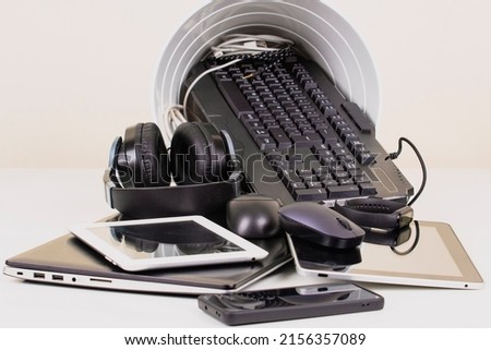 Recycling bin and old digital tablet, cell phone, headphone, cords and electronic devices. Planned obsolescence, e-waste, electronics waste for reuse and recycle concept Royalty-Free Stock Photo #2156357089