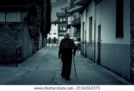 Man walking dark town street, active old age, retirement Royalty-Free Stock Photo #2156362373