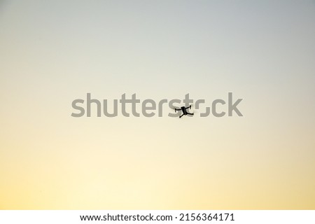 Drone flying in the sky at sunset
