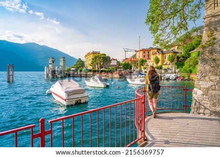 Beautiful blonde girl on The Walk of Lovers in Varenna, a pedestrian path over water, in the Lombard village of lovers on Lake Como. Varenna is the perfect place for a romantic weekend. Royalty-Free Stock Photo #2156369757