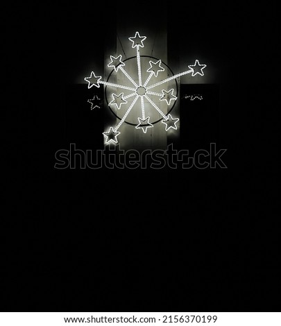 Big snowflakes of white glowing stars. Black background. Christmas mood. 