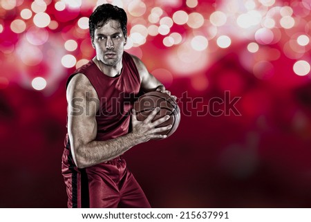 Basketball player on a  red uniform, on a red lights background.
