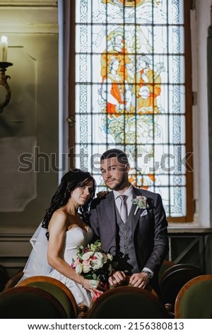 A wedding photo shoot in the organ hall. Red carpet, bridal bouquet. Beautiful antique stained glass windows