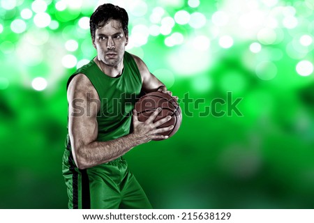 Basketball player on a  green uniform, on a green lights background.