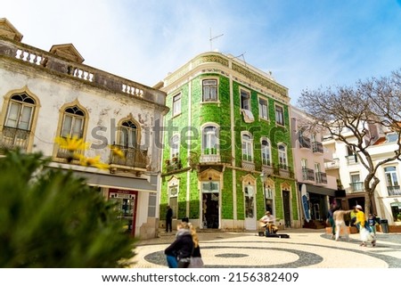 Historical town centre in Lagos, Algarve, Portugal with moving people and a green tiled building. Royalty-Free Stock Photo #2156382409