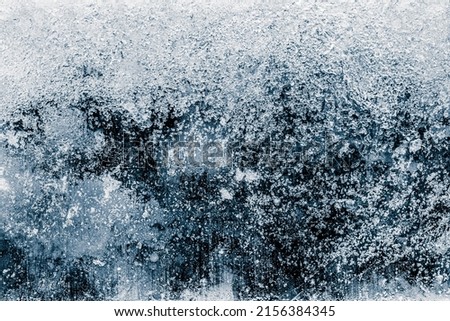 Ice texture background. The textured cold frosty surface of ice block on dark background. Royalty-Free Stock Photo #2156384345
