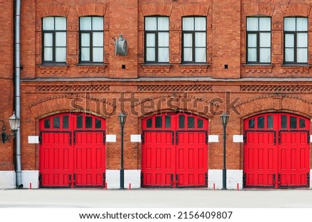 Fire station, an old historic brick building with red gates. Facade of an old fire department building Royalty-Free Stock Photo #2156409807