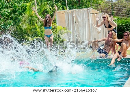 group of six friends having fun in swimmingpool outdoors