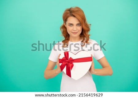 smiling woman hold heart present box on blue background