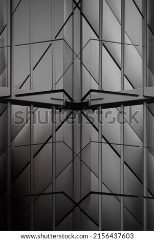 Close-up photo of metal grid structure and wall panels. Abstract architecture of modern building. Industrial or business real estate. Parallel lines. Polygonal geometric pattern of triangles.