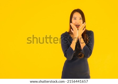 Portrait beautiful young asian woman with action on isolated yellow background