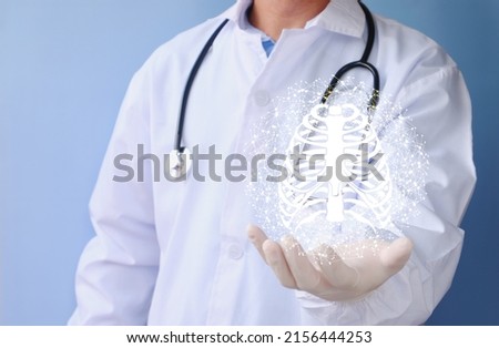 Doctor examines the bone hologram. Trauma, rheumatologist consultation, skeletal image, medical concept, future medical technologies Royalty-Free Stock Photo #2156444253