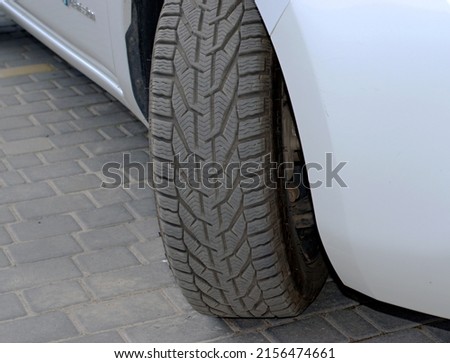 Winter car tire on a white car.