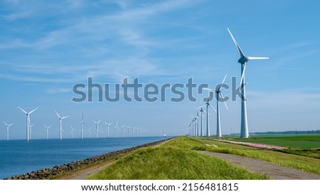 Offshore Windmill farm in the ocean Westermeerwind park, windmills isolated at sea on a beautiful bright day Netherlands Flevoland Noordoostpolder. Huge windmill turbines Royalty-Free Stock Photo #2156481815