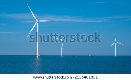 Offshore Windmill farm in the ocean Westermeerwind park, windmills isolated at sea on a beautiful bright day Netherlands Flevoland Noordoostpolder. Huge windmill turbines Royalty-Free Stock Photo #2156481851