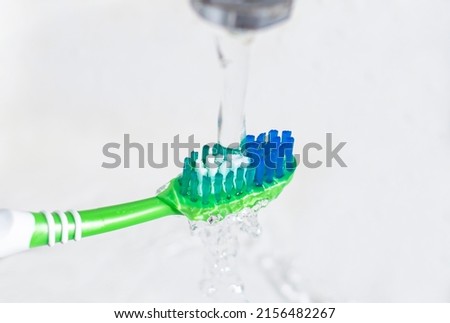 An image object close-up of a toothbrush with water to rinse regularly after use for good oral health and teeth concept on white background. Royalty-Free Stock Photo #2156482267