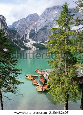 Lake Braies, Italy. Group of the traditional rowing boats docked to the wood house. Iconic location for photographers. Picturesque mountain lake in Dolomites. Wonderful nature contest. Alpine lake