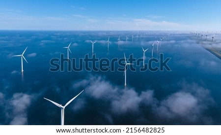 Offshore Windmill farm in the ocean Westermeerwind park, windmills isolated at sea on a beautiful bright day Netherlands Flevoland Noordoostpolder. Huge windmill turbines Royalty-Free Stock Photo #2156482825