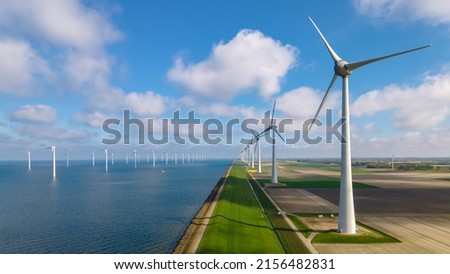 Offshore Windmill farm in the ocean Westermeerwind park, windmills isolated at sea on a beautiful bright day Netherlands Flevoland Noordoostpolder. Huge windmill turbines Royalty-Free Stock Photo #2156482831
