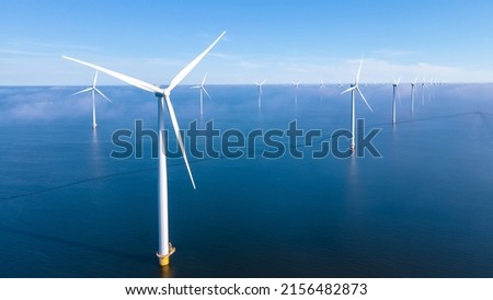 Offshore Windmill farm in the ocean Westermeerwind park, windmills isolated at sea on a beautiful bright day Netherlands Flevoland Noordoostpolder. Huge windmill turbines Royalty-Free Stock Photo #2156482873