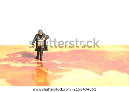 Miniature people toy figure photography. A man refugee walking above map, moving out from their country because of war conflict. Distance traveled concept. Image photo