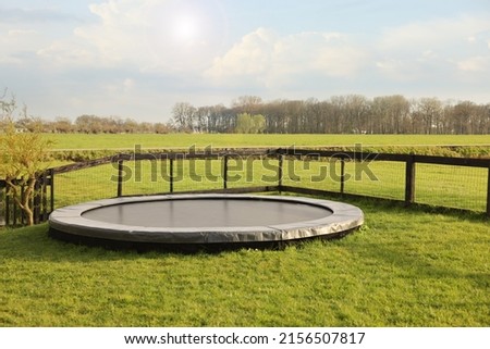 Croquet equipment and shoes near trampoline on green grass outdoors Royalty-Free Stock Photo #2156507817