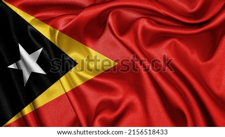 Close up realistic texture fabric textile silk satin flag of Timor-Leste waving fluttering background. National symbol of the country. 28th of November, Happy Day concept