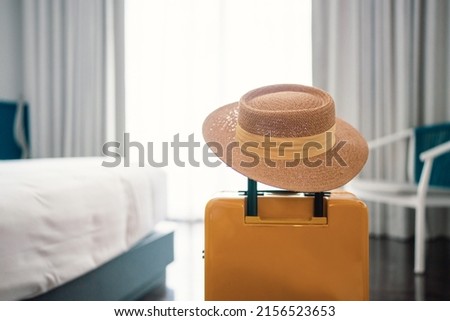 Suitcase or luggage bag with hat in a modern hotel room - relaxing time, holidays, weekend and traveling concept. copy space. Royalty-Free Stock Photo #2156523653