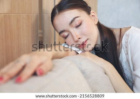 Portrait picture of Young Caucasian woman smile relax before sleep laying on sofa bed