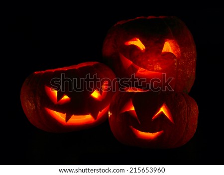 Illuminated cute halloween pumpkins isolated on black background