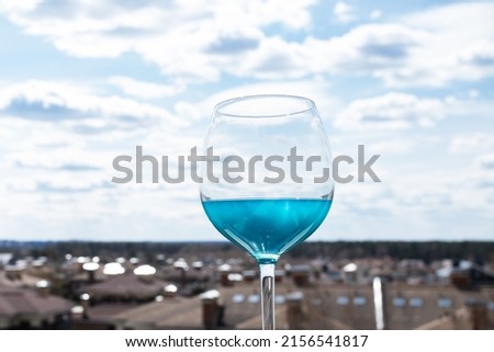 summer cocktail, blue drink in a glass on the background of the city