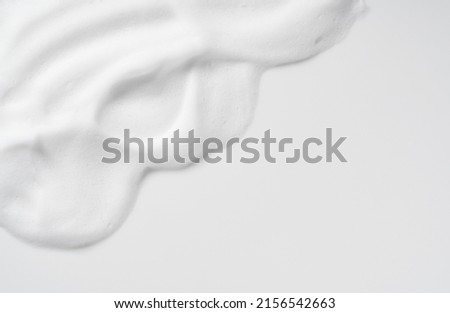 Skincare cleanser foam texture. Copy space and soap bubbles on white background. View from directly above. Royalty-Free Stock Photo #2156542663
