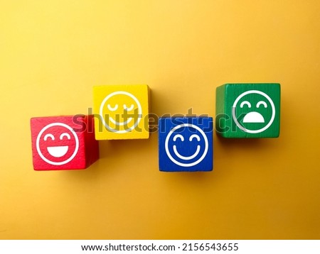 The colored wooden block with happy and unhappy expression isolated on yellow background