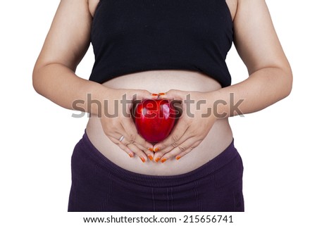 Close up of pregnant woman holding a red apple, isolated on white