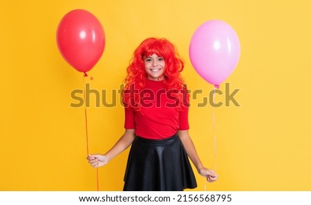 glad girl with party balloon on yellow background