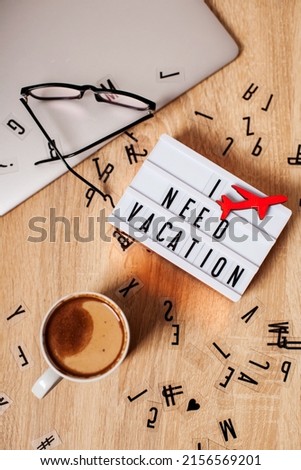 I need a vacation. The inscription on the lightbox. Background. flat lay with coffee, computer and glasses on a table with letters scattered. call to action. mock up