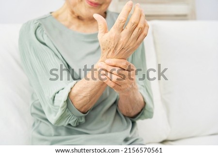Asian senior woman having the joint pain at home, no face