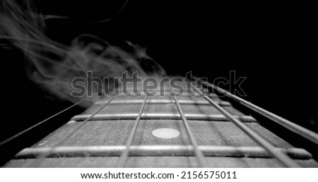 Guitar fretboard with sliding in black and white closeup Royalty-Free Stock Photo #2156575011