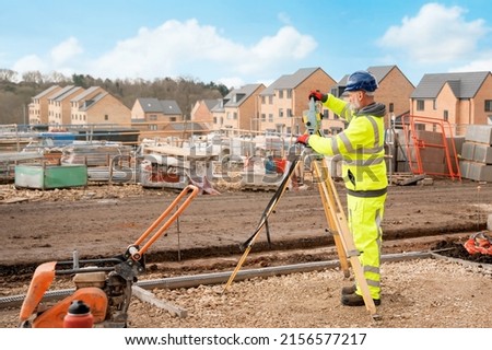 Site engineer in hi-viz installing surveying instrument on construction site Royalty-Free Stock Photo #2156577217