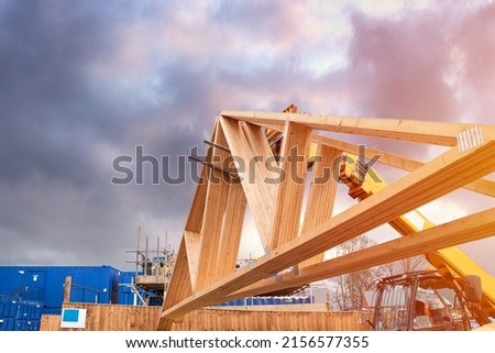 Forklift shifting roof trusses on new residential housing development construction site Royalty-Free Stock Photo #2156577355