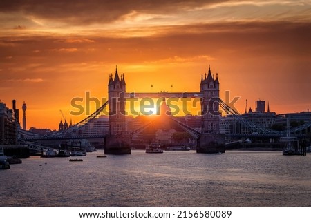 Beautiful sunset view of the Tower Bridge of London, United Kingdom, lifted up with passing by boats on the Thames River