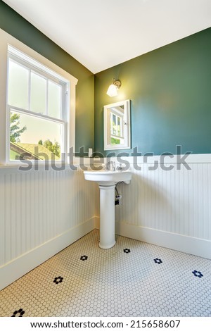 White bathroom interior with white and green wall trim. White washbasin stand