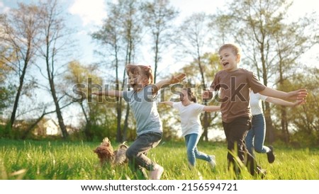 group of children running in the park. happy family baby kid dream concept. kindergarten. children hands to the sides play pilots plane run on the grass in the summer in the lifestyle park Royalty-Free Stock Photo #2156594721