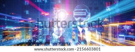 Businessman wearing VR glasses to join metaverse, virtual reality, networking applications, web3.0, virtual world and simulation. Futuristic concept background with double exposure. Royalty-Free Stock Photo #2156603801